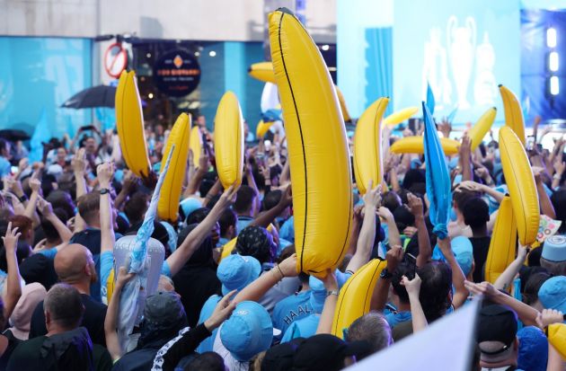 Manchester City fans with their infamous inflatable bananas at the treble trophy parade